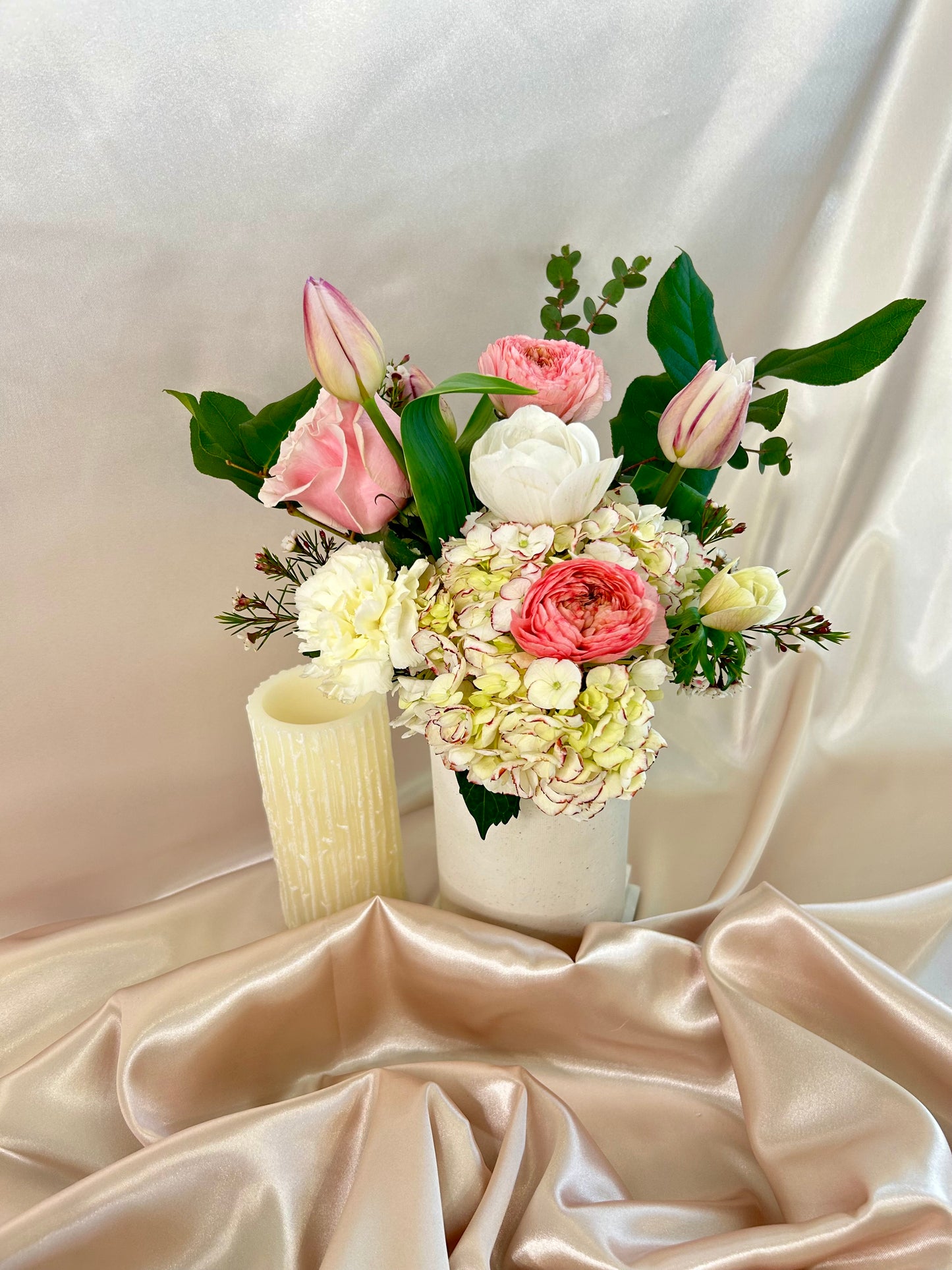 A white, pink, and purple floral bouquet from Dolci Fiori Florist in a tall white vase.